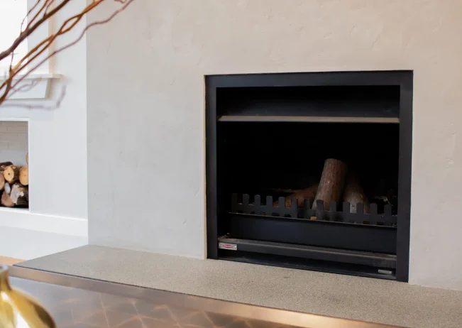 Modern indoor fireplace with timber surround in Parnell Residence
