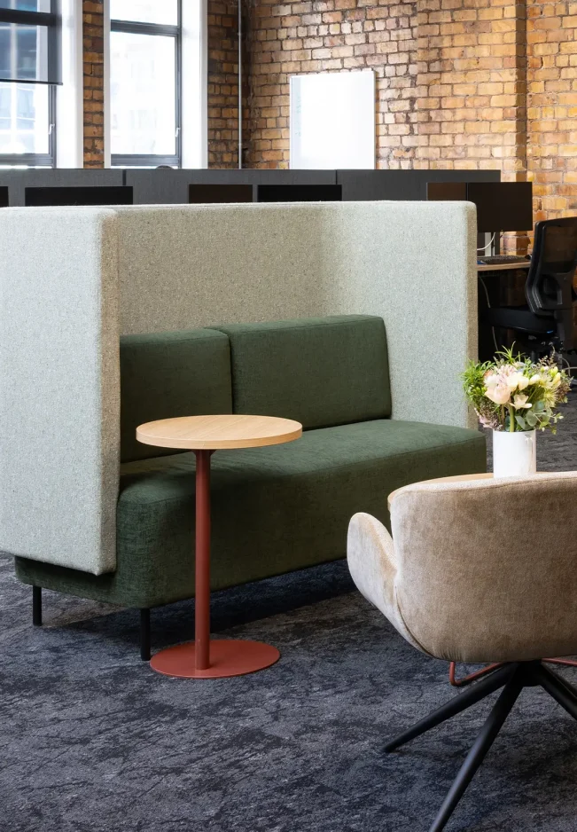 Open-plan workspace with desks, partition screens, and natural lighting