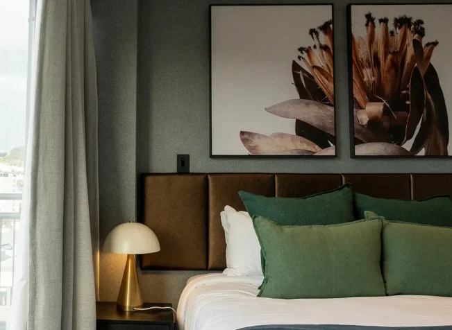 TRYP Penthouse master bedroom with green cushions and wall art